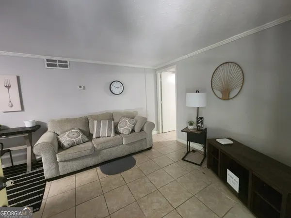 a living room with furniture a couch and potted plant