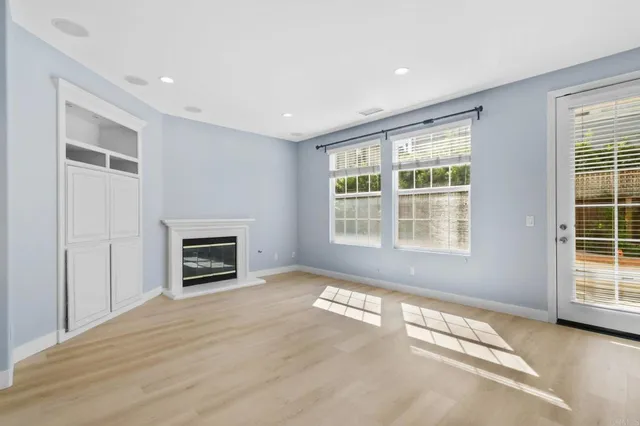 a view of empty room with a fireplace and windows