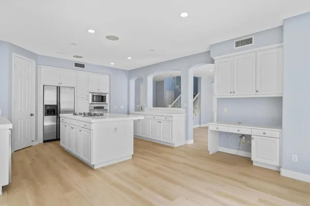 a kitchen with white cabinets and white appliances
