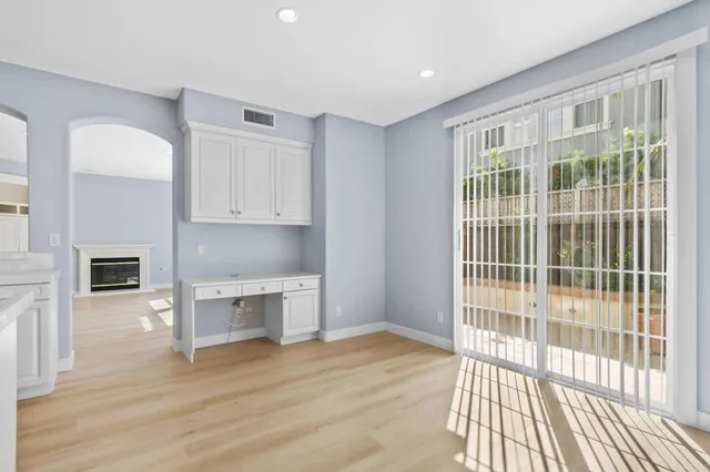 a view of a kitchen with wooden floor and a fireplace