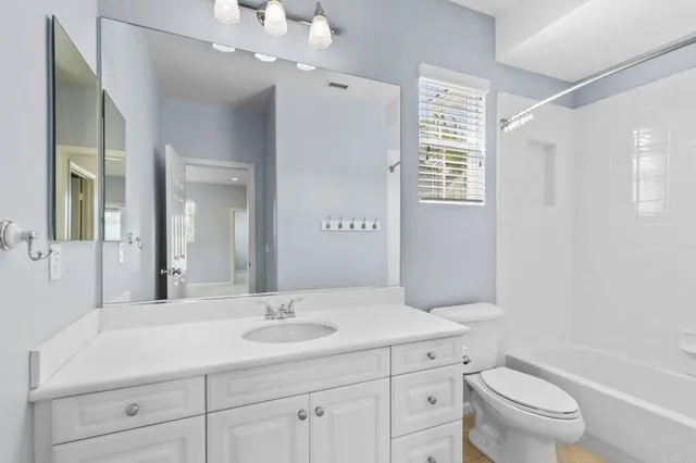 a bathroom with a sink a toilet a large mirror and shower