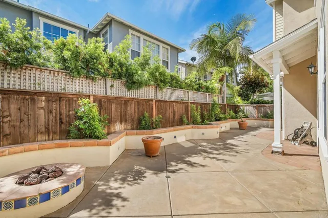a view of a backyard with plants and iron fence