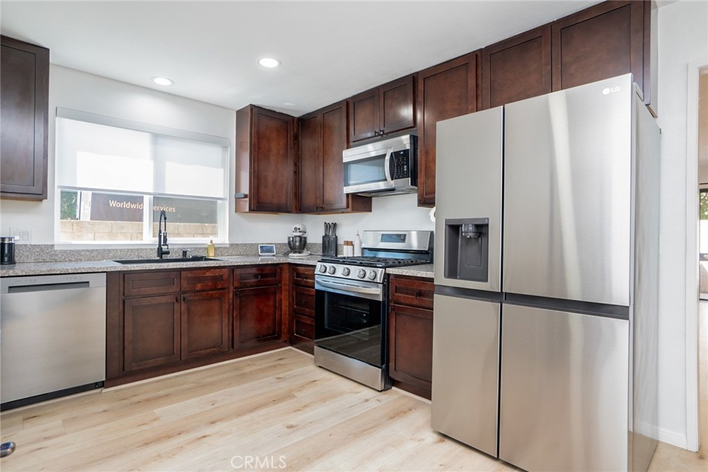 8025 70th Street Paramount, CA 90723 - Photo 11 of 31 a kitchen with stainless steel appliances granite countertop a refrigerator stove microwave and sink