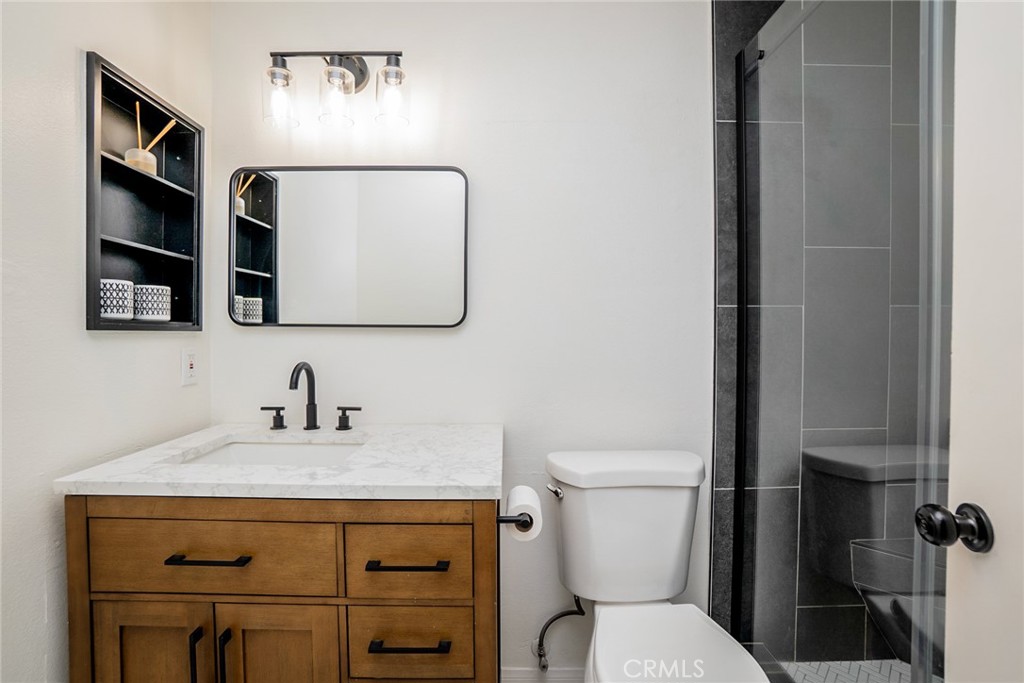 8025 70th Street Paramount, CA 90723 - Photo 20 of 31 a bathroom with a toilet sink and mirror
