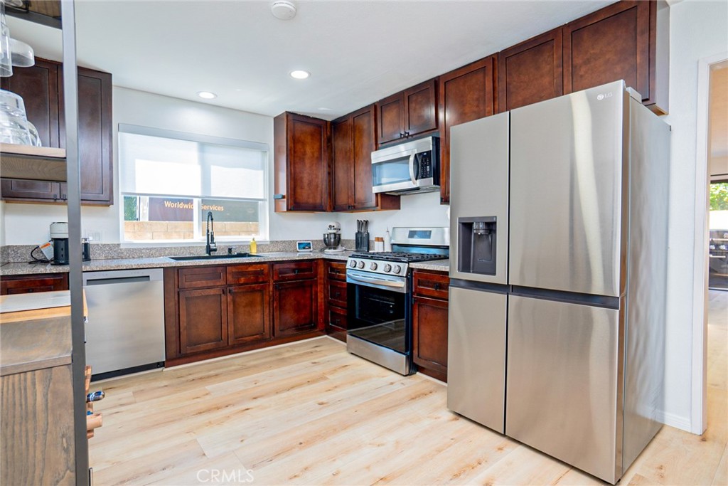 8025 70th Street Paramount, CA 90723 - Photo 9 of 31 a kitchen with stainless steel appliances granite countertop a refrigerator sink and cabinets