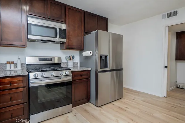 a kitchen with stainless steel appliances granite countertop a refrigerator stove microwave and sink