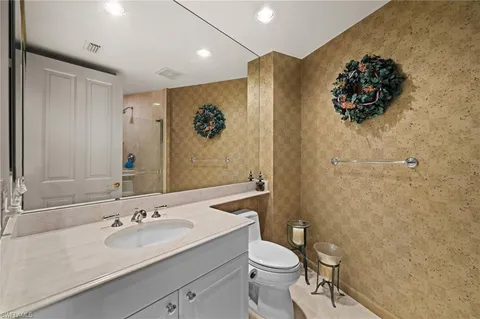 a bathroom with a sink mirror vanity and toilet