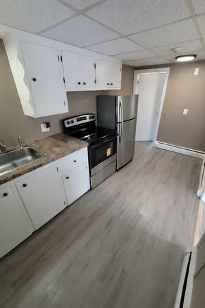 a kitchen with granite countertop a sink and cabinets