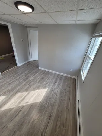 a view of empty room with wooden floor