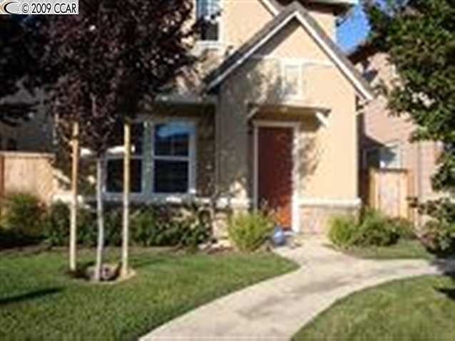 a view of a house with brick walls and a yard with plants