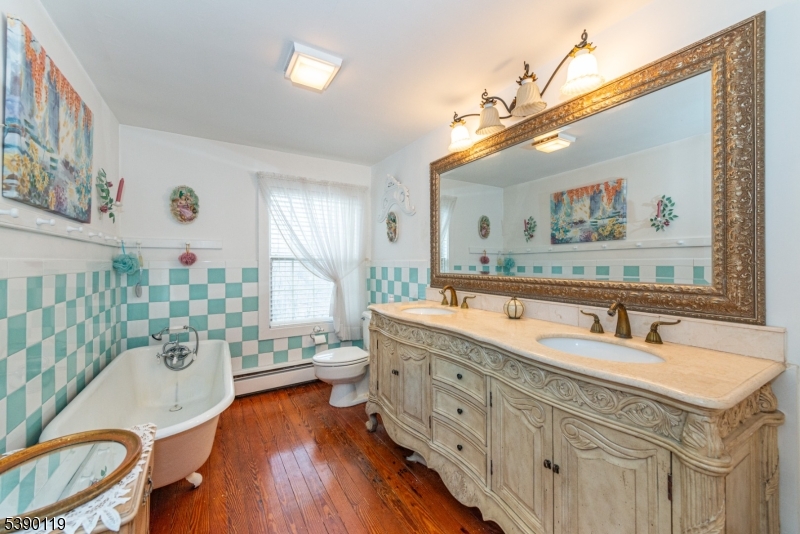 107 Clove Road, Unit 3 Wantage, NJ 07461 - Photo 18 of 45 a spacious bathroom with a double vanity sink a mirror a bathtub and a toilet