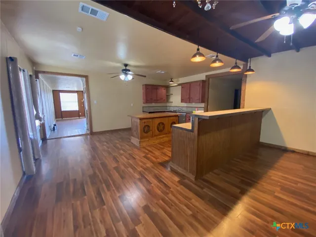 a open kitchen with wooden floors and a sink