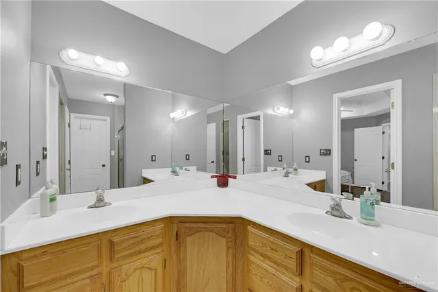 a bathroom with a sink double vanity granite and a mirror