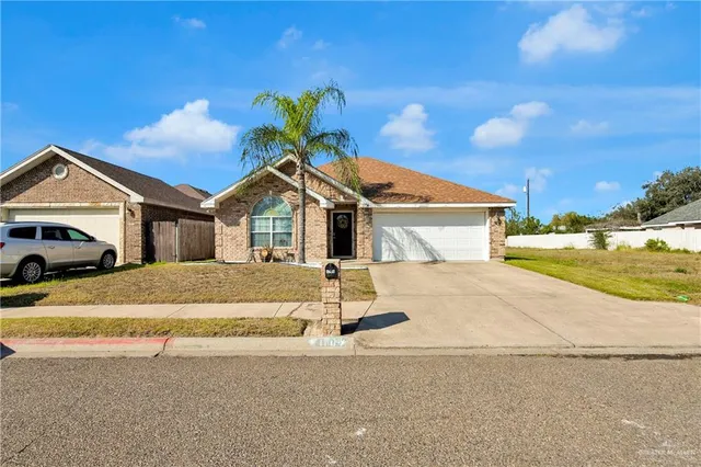 a front view of a house with a garden and parking