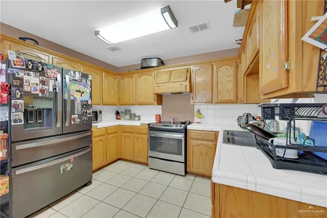 a kitchen with a sink appliances and cabinets