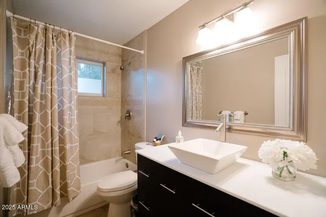 a bathroom with a sink a toilet a mirror and shower