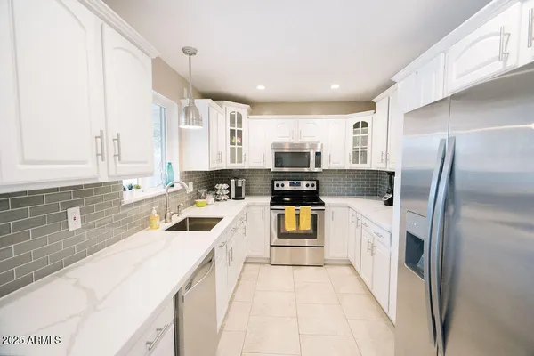 a kitchen with stainless steel appliances granite countertop a refrigerator and a sink