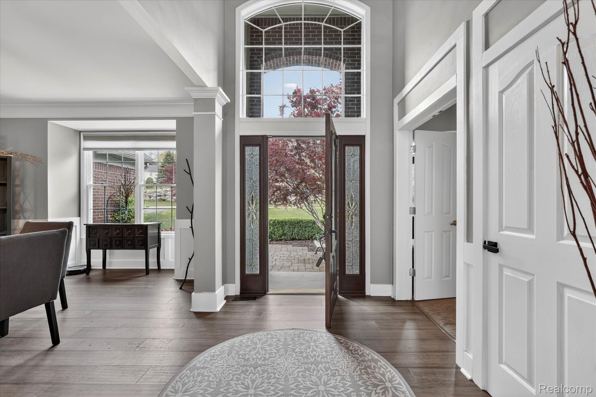 9074 Ridgefield Drive Brighton, MI 48114 - Photo 3 of 75 Entryway with a high ceiling, dark wood-type flooring, plenty of natural light, and ornate columns