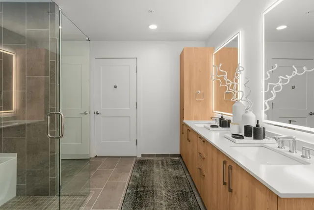a bathroom with double vanity and a bathtub