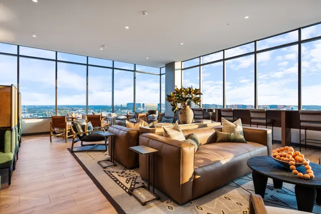 a living room with furniture large windows and a view of balcony