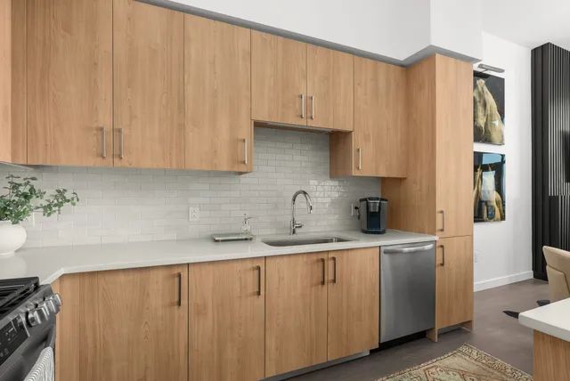 a kitchen with a sink a refrigerator and cabinets