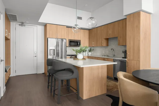 a kitchen with a table chairs refrigerator and microwave