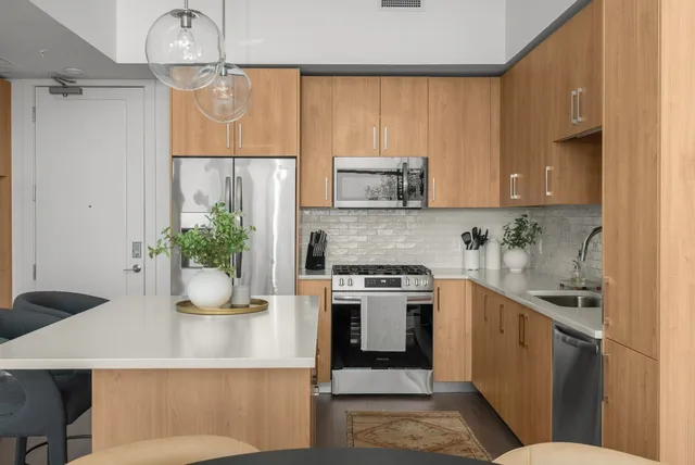 a kitchen with stainless steel appliances a stove a sink and a refrigerator