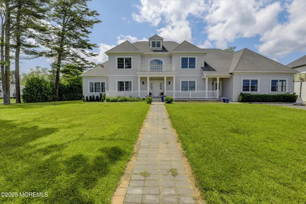 a view of a brick house with a big yard and large trees