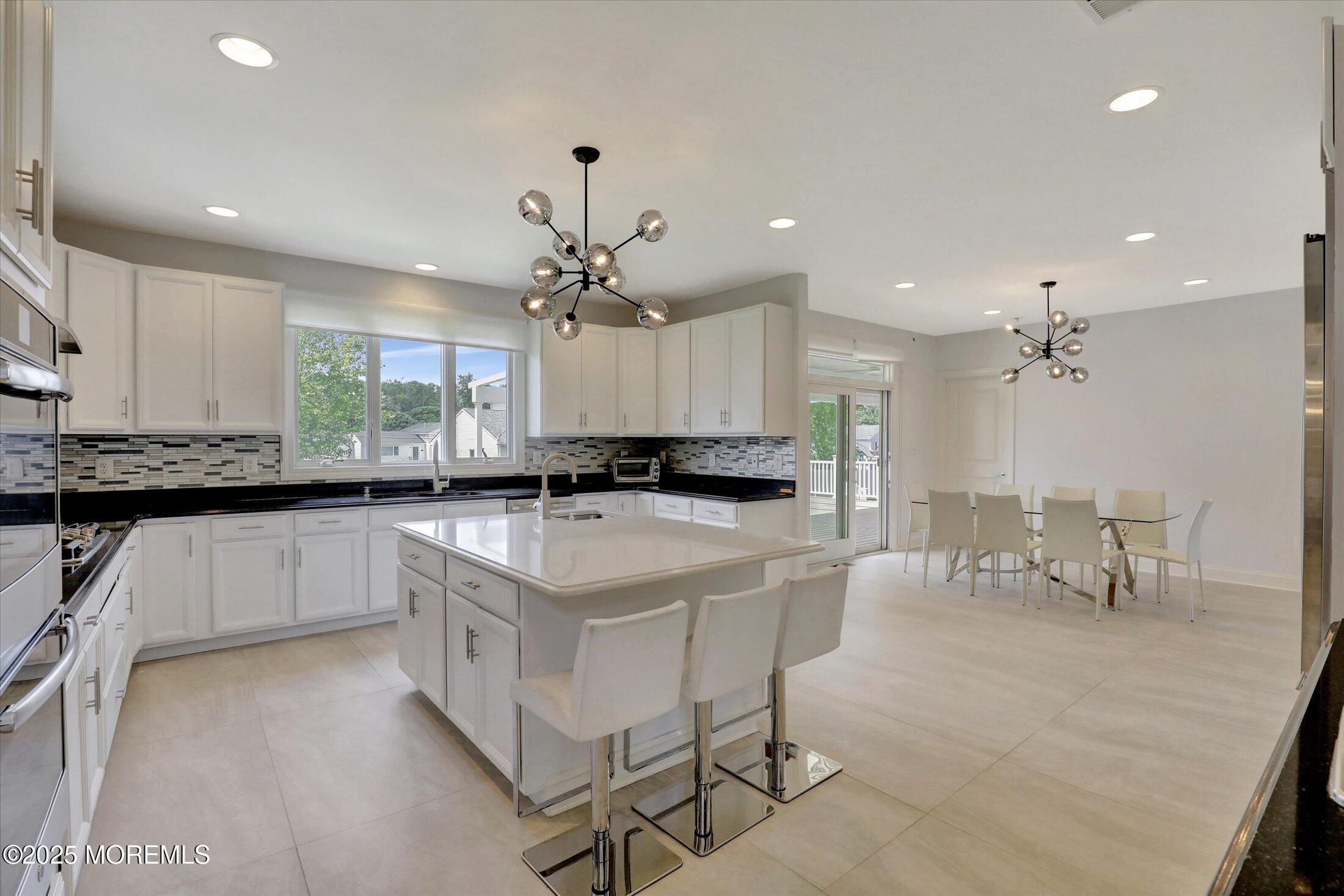 1 Country Club Drive Deal, NJ 07723 - Photo 26 of 65 a open kitchen with stainless steel appliances granite countertop a stove a sink a refrigerator and white cabinets with wooden floor