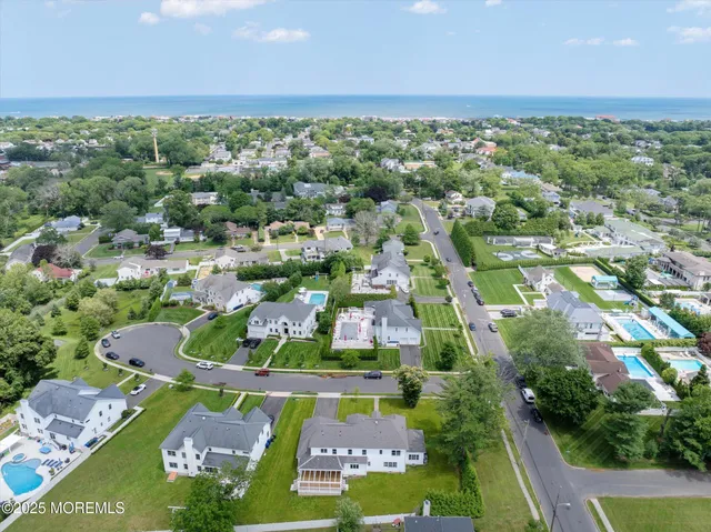 an aerial view of residential houses with outdoor space and trees