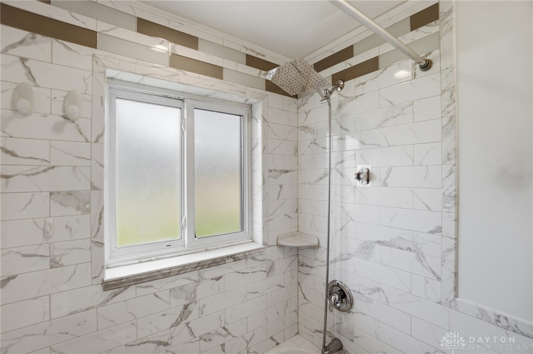 629 Storms Road Dayton, OH 45429 - Photo 37 of 51 This bright bathroom features elegant tiling and a modern rainfall shower head.