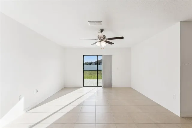an empty room with a ceiling fan and a window