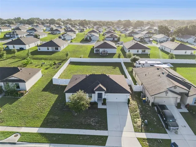 an aerial view of a pool yard and mountain view in back