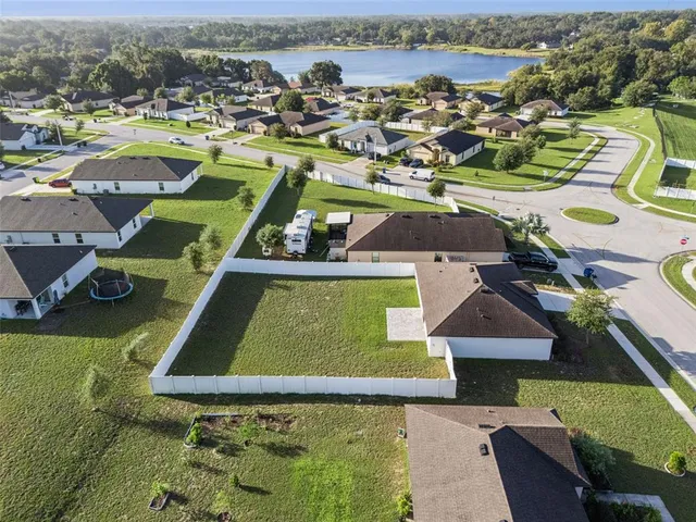 an aerial view of a residential houses with outdoor space and lake view