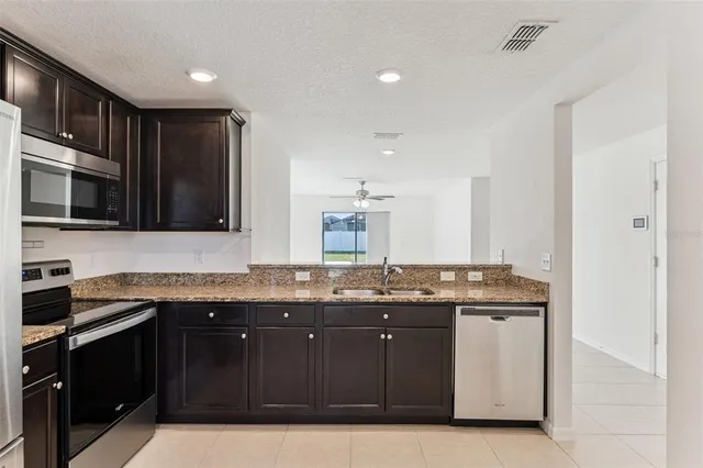 a kitchen with a sink and a stove top oven with wooden floor