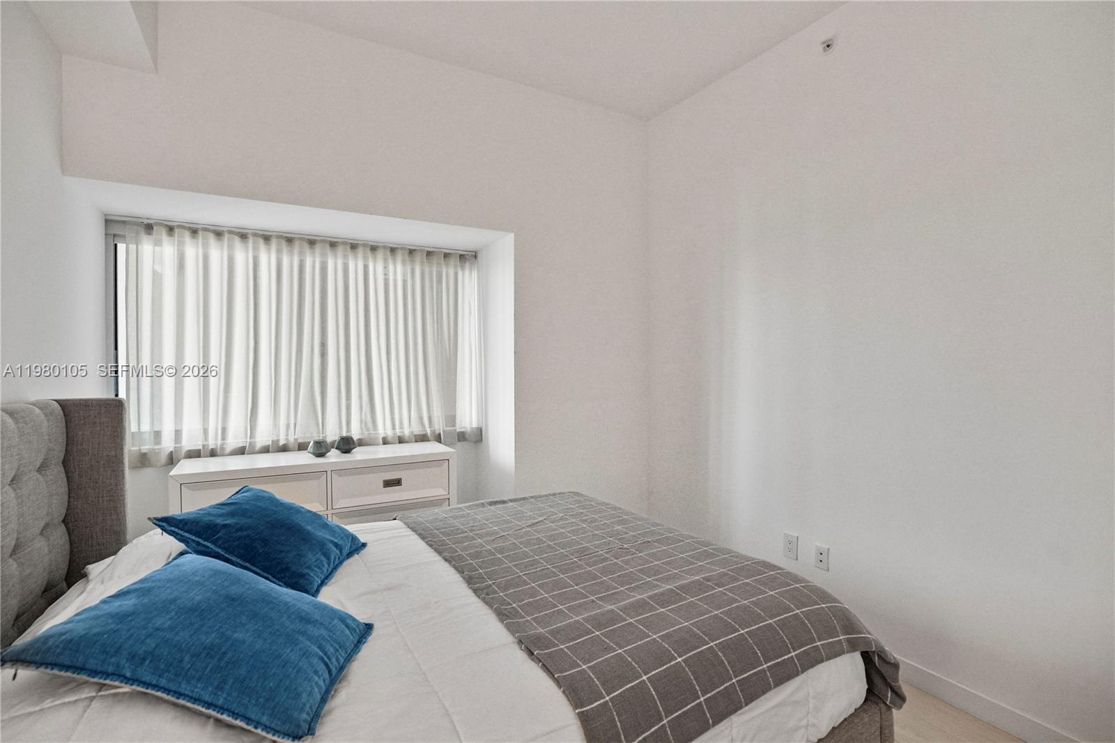 480 Northeast 31st Street, Unit 3906 Miami, FL 33137 - Photo 29 of 38 a bedroom with a bed and a window