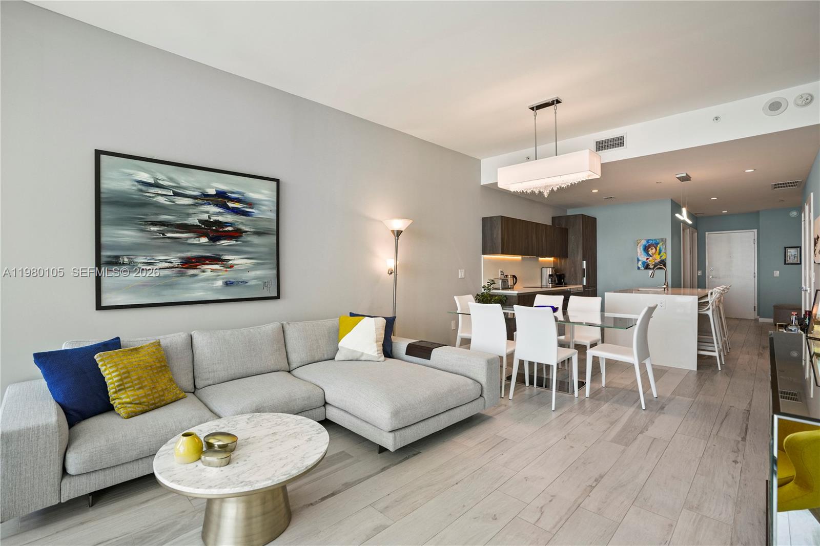 480 Northeast 31st Street, Unit 3906 Miami, FL 33137 - Photo 5 of 38 a living room with furniture kitchen view and a chandelier