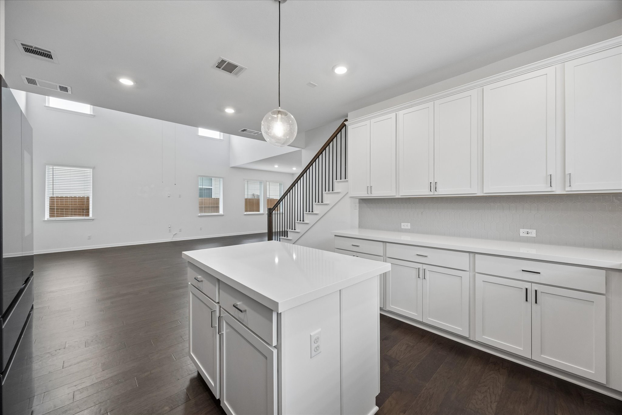 6407 Rounded Pebble Lane Buda, TX 78610 - Photo 11 of 32 Bright open-concept kitchen and living area feature a central island and rich hardwood flooring.