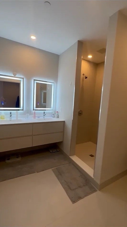44-46 Temple Place, Unit 3 Boston, MA 02111 - Photo 8 of 11 a bathroom with a double vanity sink a mirror and a bathtub