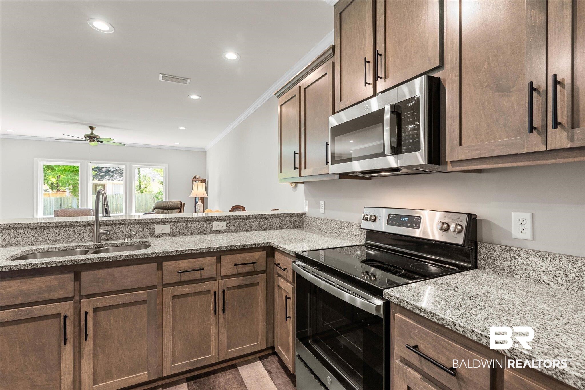 1101 Pinemont Drive Mobile, AL 36609 - Photo 8 of 18 Kitchen featuring light stone counters, a sink, appliances with stainless steel finishes, ornamental molding, and visible vents