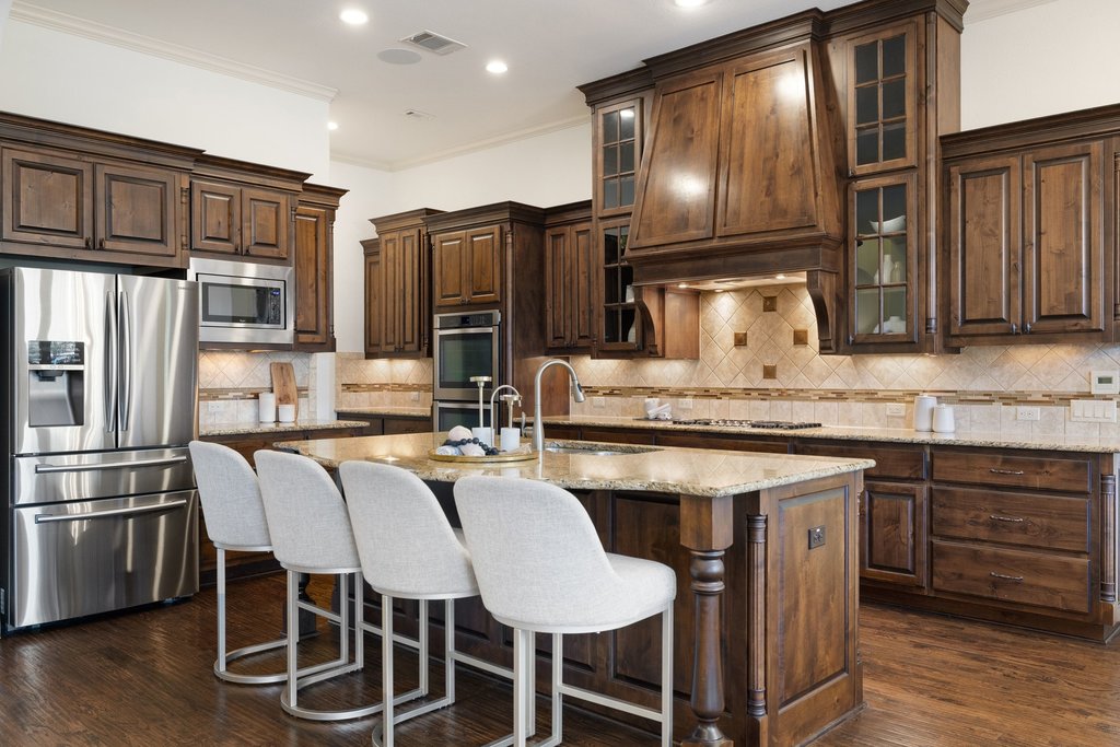 5804 Davenport Divide Road Austin, TX 78738 - Photo 13 of 40 a kitchen with stainless steel appliances kitchen island granite countertop a kitchen island and chairs in it