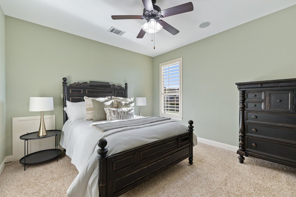 5804 Davenport Divide Road Austin, TX 78738 - Photo 28 of 40 a bedroom with a bed and a ceiling fan