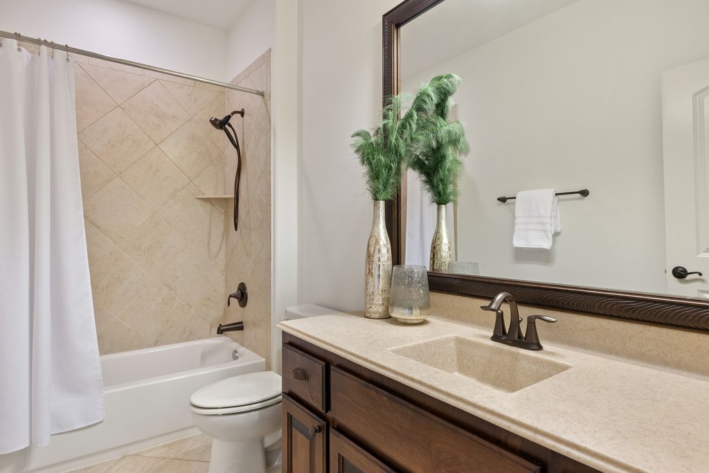 5804 Davenport Divide Road Austin, TX 78738 - Photo 30 of 40 a bathroom with a granite countertop sink a toilet and shower