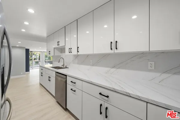 a large kitchen with stainless steel appliances kitchen island granite countertop a sink a stove and a refrigerator