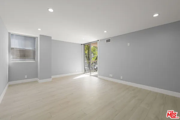 an empty room with windows and closet