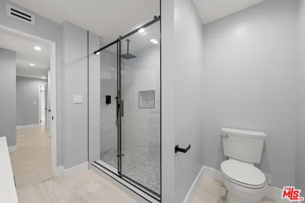 a bathroom with a shower a toilet and a sink