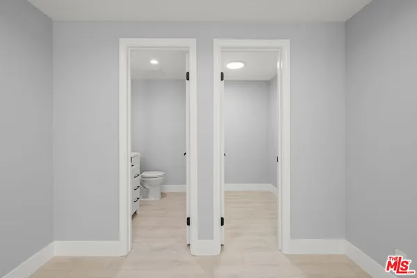 a view of bathroom with a glass door and a toilet