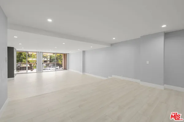 a view of an empty room with a floor to ceiling window and outside view