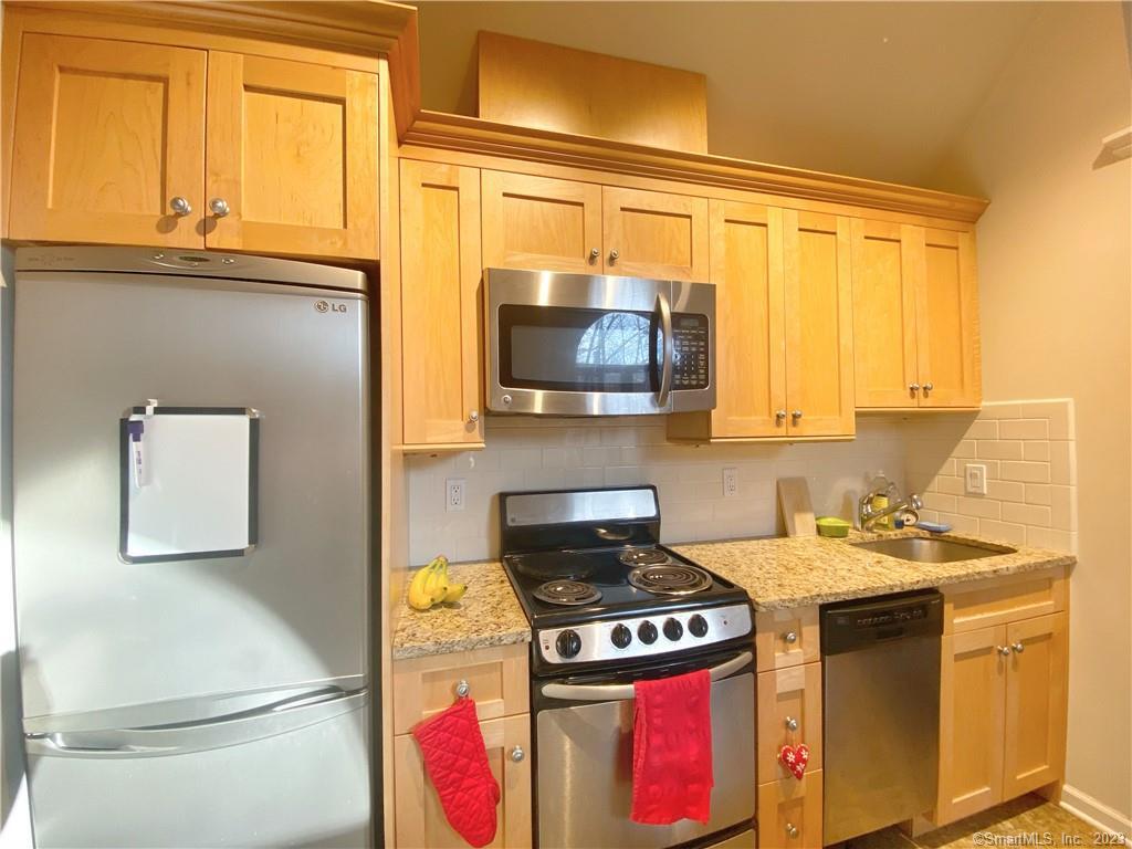 a kitchen with stainless steel appliances a stove a microwave and a refrigerator