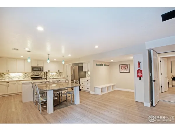 a kitchen with kitchen island a sink white cabinets and appliances